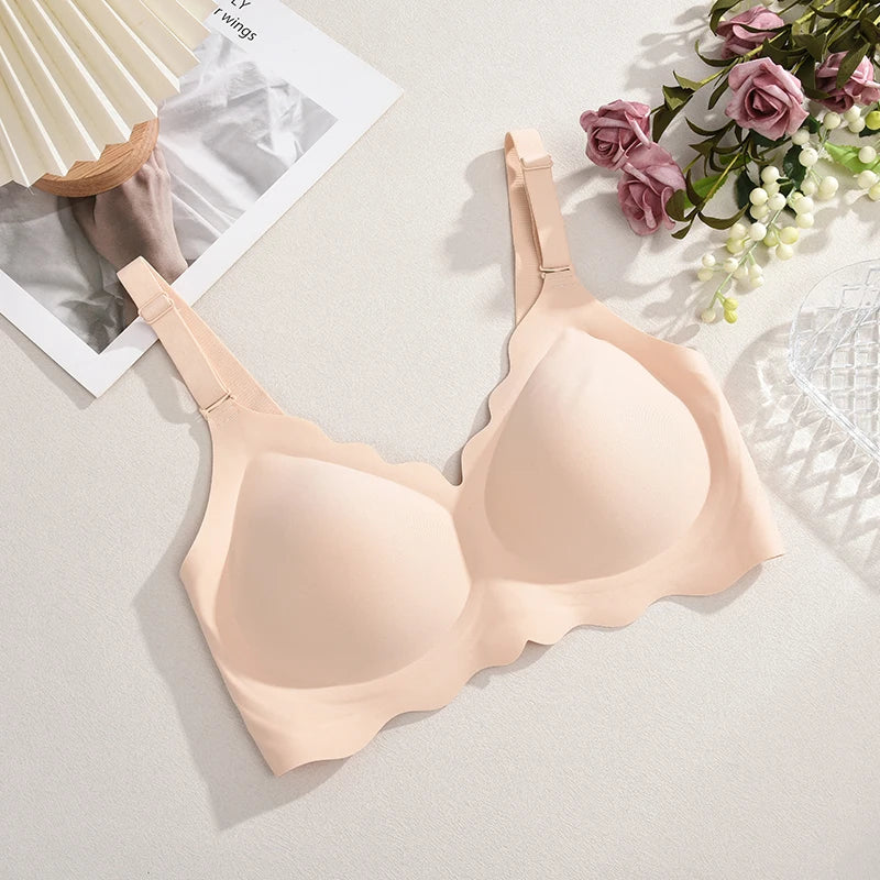Beige bra on a light gray surface with flowers and a magazine in the background