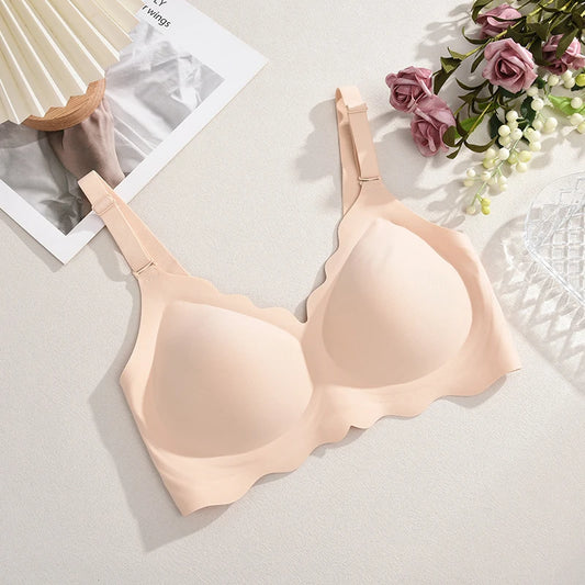 Beige bra on a light gray surface with flowers and a magazine in the background
