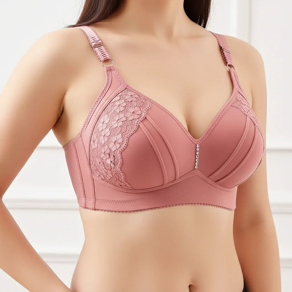Pink bra with lace details worn by a model on a white background
