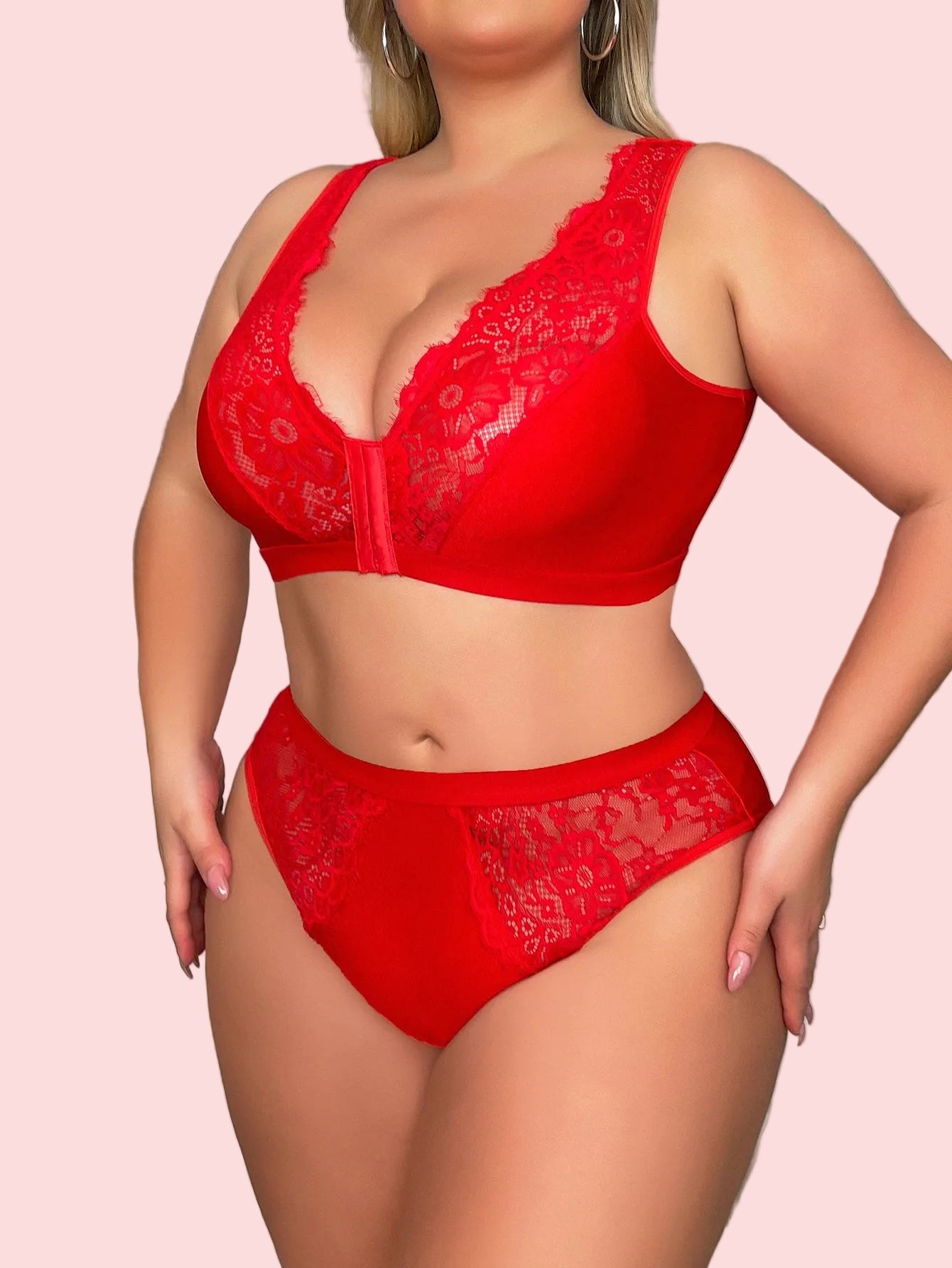 Red lace lingerie set worn by a model on a staircase.