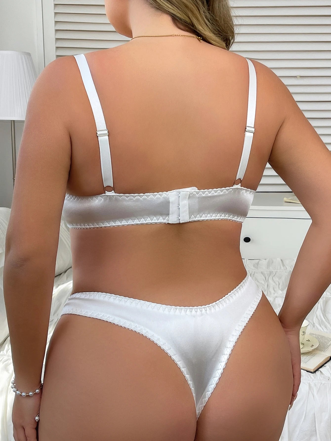 White lingerie set worn by a person in a neutral indoor setting