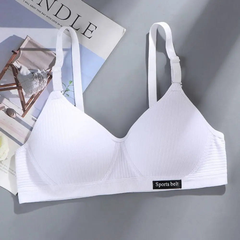 White bra on a gray surface with a magazine in the background