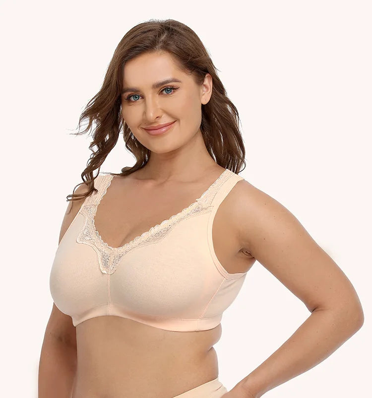 Woman wearing a beige bra with lace details on a plain background